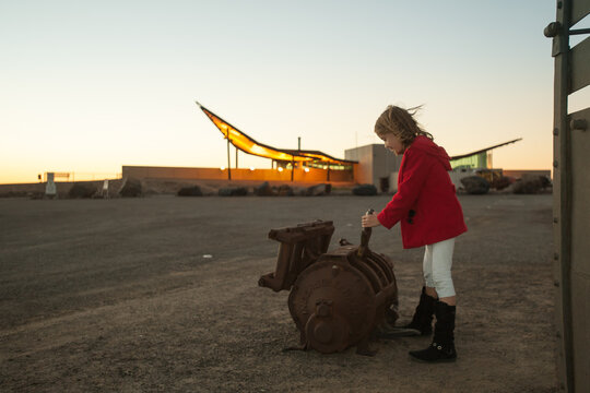 Girl playing with old mining tools at Broken Hills tourism center at dusk