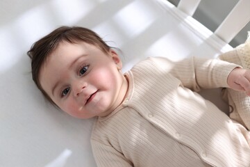 Bedtime. Cute little baby in crib at home, top view