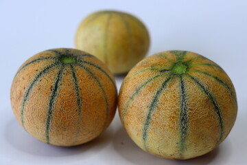Whole Madhu muskmelons also known as cantaloupe or kharbooja with netted rind and subtle green...