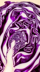 Obraz premium Close-up cross-section of purple cabbage showing intricate geometric pattern of leaves, isolated on light beige background, vibrant vegetable macro photography, fresh produce detail