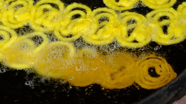 Jalebi is a famous indian sweet. frying sweets jalebi in oil, indian, Bangali and pakistani dessert mithai, Spiral crunchy candies fried in oil