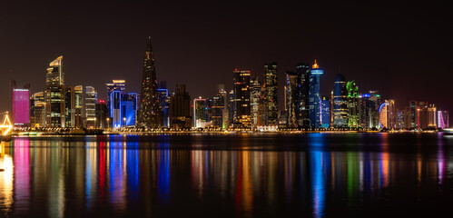 Naklejka premium Doha skyline view with sea. night scene, beautiful panoramic view of Doha from the sea at night.