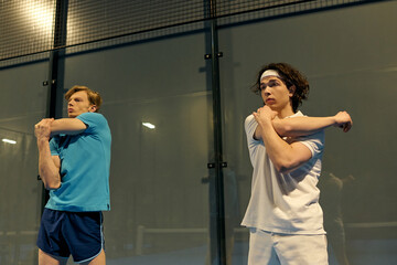 Young sportsmen preparing for a competitive match on the padel court