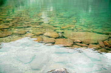 Crystal clear alpine lake water with visible stones on the bottom in Austria