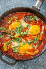 Shakshuka with mushrooms and yellow peppers topped with eggs and cilantro