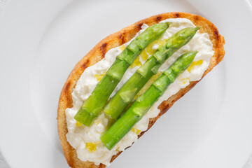 Grilled sandwich with white bread, stracciatella cheese, and green asparagus