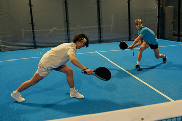 Young padel players engage in a dynamic match on a vibrant court