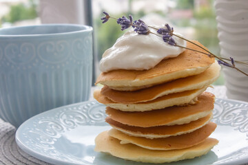 pancakes with sour cream and lavender flowers close-up for breakfast