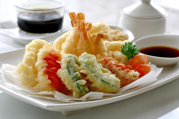 Delicious Tempura with Dipping Sauce. A beautifully plated assortment of tempura, served with dipping sauce, showcasing the textures and colors of Japanese cuisine.