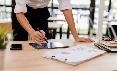 Business asian woman financial expert analyzes business report graph and chart at the office....