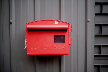 An empty red letterbox attached at the entrance to a house