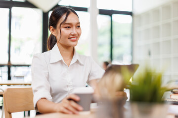 Obraz premium Young asian business woman manager accounting analyst checking bills, analyzing sales statistics management, taxes financial data documents or marketing report papers working in office using laptop. 