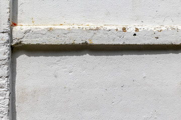 Weathered white concrete wall with horizontal pipe shadow