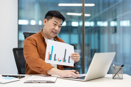 An Asian man presents financial data during an online business meeting, discussing charts and graphs on a video call.