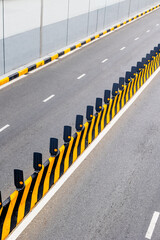Empty urban road with yellow black barriers and reflectors