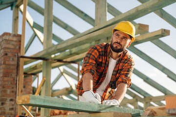 Construction worker is on the roof of a house