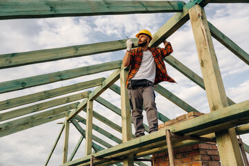 Walkie talkie radio. Construction worker is on the roof of a house
