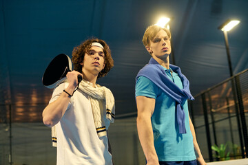Young sportsmen showcase their skills on an indoor padel court during a lively match