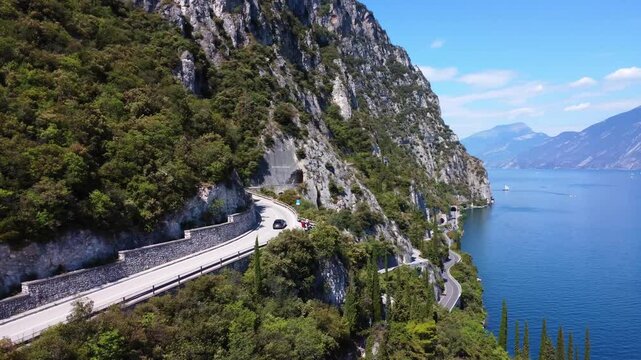 Drone shot of Strada della Forra curving through cliffs above Lake Garda. This legendary Italian road offers tunnels, dramatic drops, and one of Europe&rsquo;s most scenic drives.