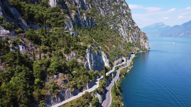 Breathtaking drone view of Strada della Forra, the iconic road winding along Lake Garda&rsquo;s cliffs. A stunning blend of nature, tunnels, and lake views in northern Italy.