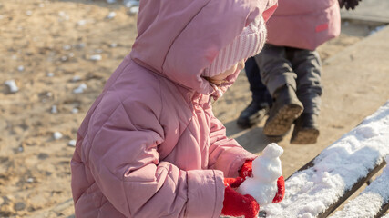 Grandfather playing with her granddaughters on the playground in the park in winter