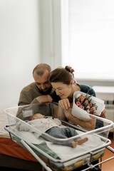 A newborn baby sleeping peacefully in a hospital bassinet, wearing a cozy outfit.