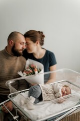 A newborn baby sleeping peacefully in a hospital bassinet, wearing a cozy outfit.