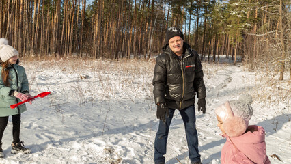 Playful family enjoying snowball fight in snowy winter park
