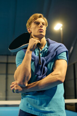 Young sportsman preparing for a challenging padel match on an indoor court