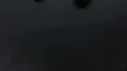 Sequence showing layered pastel paper flowers sliding downward on black tabletop, revealing surface - Powered by Adobe