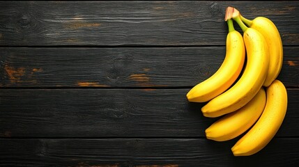 Yellow bananas on dark wooden planks
