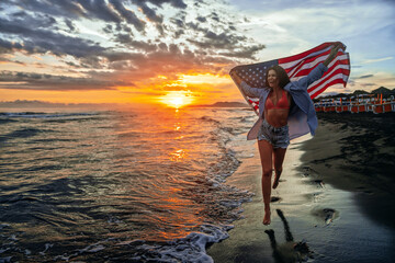 Happy woman holding american USA flag and running on the beach. Independence Day, travel concept