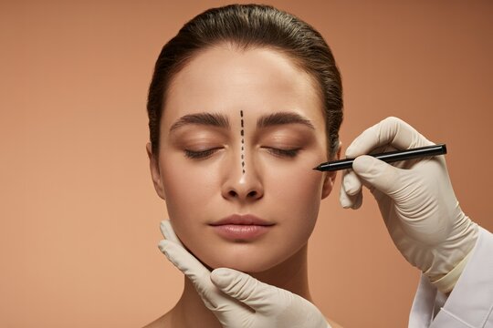 Plastic surgery preparation concept with surgeon drawing face marks for cosmetic beauty enhancement.