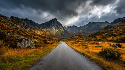 Scenic mountain road with majestic autumn landscape and dramatic cloudy sky in remote area of Lofoten Norway .