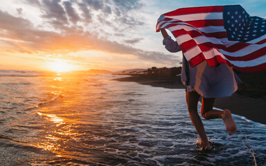 Happy woman smiling and running on beach with the US flag. July 4th independence day. Holiday