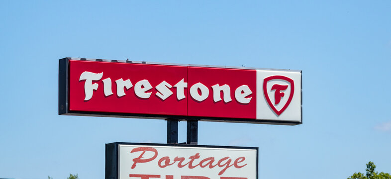 Firestone store sign against blue sky. Portage, IN USA - June 28, 2025