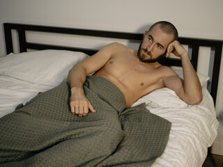 Young attractive man resting on his bed at home after work.