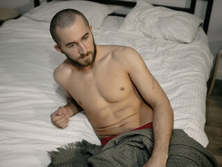 Young attractive man resting on his bed at home after work.