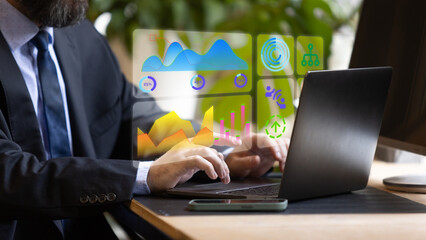 Businessman types on laptop while analyzing bright digital dashboard with stats, charts, graphs, and icons in a modern, tech-enabled office. Concept of performance data visualization