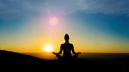 Women practicing yoga at sunset. Yogi sitting back in lotus position.