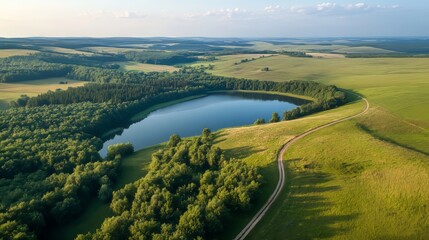 Aerial view of a country road in a green summer forest and lake