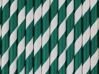 Full frame of many green and white striped paper straws.