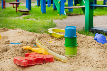 Empty children's sandbox with colorful toys. Children's recreation in summer. Playground for children