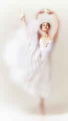 Poised faded ballerina in mid air, dressed in a flowing white gown with floral adornment, performs...