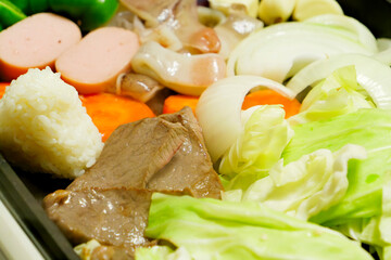 Beef, vegetables, rice balls, and yakiniku grilled on a hot plate