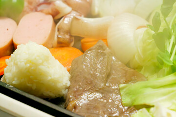 Beef, vegetables, rice balls, and yakiniku grilled on a hot plate