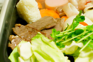Beef, vegetables, rice balls, and yakiniku grilled on a hot plate