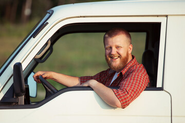 Happy driver behind the wheel of his car.