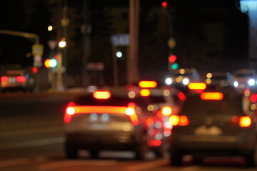 Cars Waiting at Traffic Light on City Street at Night with Bokeh Lights
