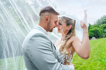 beautiful wedding couple kissing under the veil